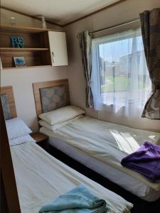 塞尔西Holiday Escapes的小型客房 - 带2张床和窗户