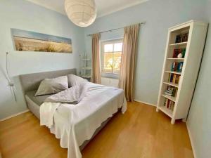 格拉尔-米里茨discovAIR Graal-Müritz -Villa Victoria- Strandnah mit Netflix的一间卧室设有一张床和一个书架