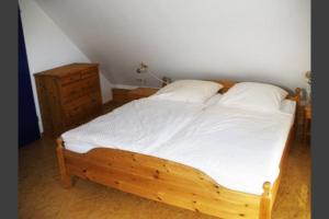 博尔库姆Deetje的一间卧室配有木床和梳妆台