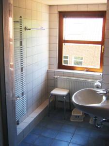 博尔库姆Deetje的一间带水槽、椅子和窗户的浴室