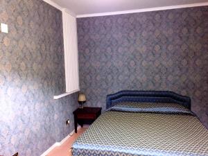 科森扎Hotel Excelsior的一间卧室配有一张带蓝色和白色棉被的床