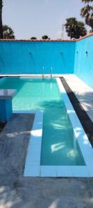 贾夫纳Palm Path Resort的蓝色的游泳池,里面设有长凳