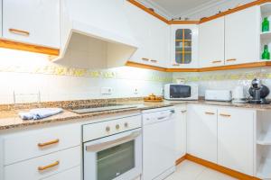 穆罗海滩North House的厨房配有白色橱柜和微波炉