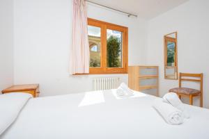 穆罗海滩North House的卧室配有白色的床和窗户。