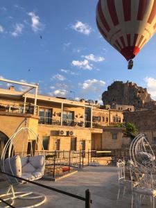 乌奇希萨尔Karlık Cave Suite Cappadocia的飞过大楼的热气球