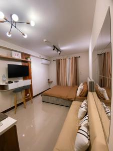 Lapu Lapu CitySaekyung Condominium的一间卧室配有一张床、一张书桌和一台电视