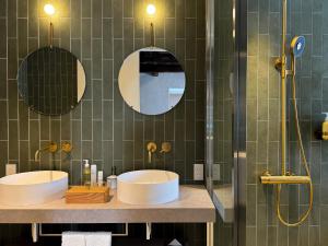 函馆Portside Inn Hakodate的浴室设有2个水槽和2个镜子