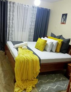 尼耶利Moh Cabins的床上有黄色枕头,有黄色的毯子