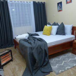 尼耶利Moh Cabins的一间卧室配有一张带黑色床单和枕头的床。