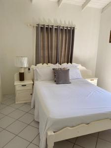 UnionStunning Villa overlooking Friendship Bay Beach的一间卧室配有带白色床单和枕头的床。