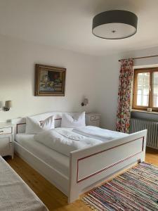 若特阿赫-埃根Haus Kaiser的卧室配有白色的床和窗户。