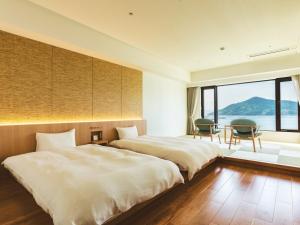 EtajimaEtajimasou Hotel & SPA Hiroshima的配有两张床铺的客房配有桌椅