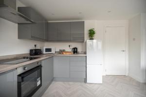 蒂斯河畔斯托克顿Woodham House By Horizon Stays的厨房配有白色橱柜和白色冰箱。
