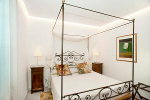 阿雷佐卡德法拉堤住宅酒店的一间卧室配有带枕头的黑色天蓬床