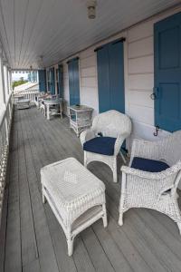 克里斯琴斯特德The Roosters Perch - A Quaint Island Homestead的门廊上的一组柳条椅和桌子