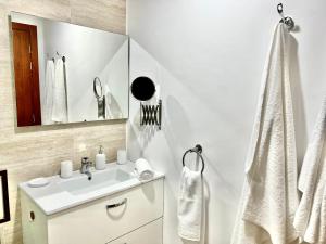 马拉喀什Luxury apartments的白色的浴室设有水槽和镜子