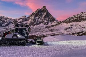 布勒伊-切尔维尼亚FAIRWAY LODGE的停在山前的雪地推土机