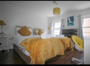 新港Wheatsheaf Hotel的一间卧室配有一张床和一张黄色椅子