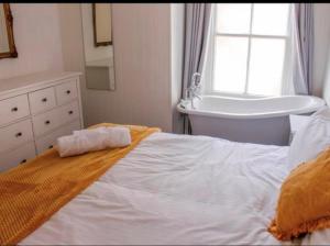 新港Wheatsheaf Hotel的一间卧室配有一张床、一个浴缸和一个水槽