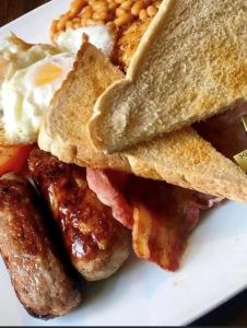 新港Wheatsheaf Hotel的包括鸡蛋香肠和烤面包的早餐食品