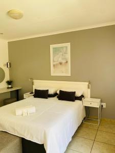 圣卢西亚圣卢西亚狩猎旅馆的卧室配有一张带两个枕头的大白色床