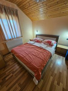 斯莫利亚纳茨米里亚娜宾馆的一间卧室设有一张带木制天花板的大床