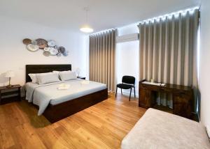 里斯本Lisboa Intendente 3Bedroom Apartment with Balcony的一间卧室配有一张床、一张桌子和一把椅子