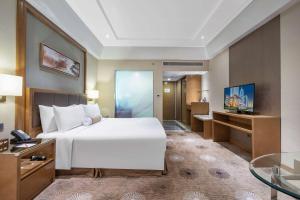上海上海浦东华美达大酒店的卧室配有一张白色大床和电视。