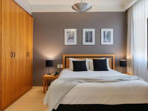 贝洛奥里藏特萨法斯美居BH酒店的一间卧室设有一张大床和棕色的墙壁