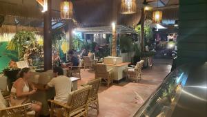 苏梅岛Premium Party Hostel的一群坐在餐厅桌子上的人