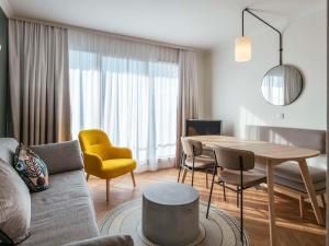 巴黎巴黎肖蒙山丘阿德吉奥公寓式酒店的客厅配有桌子和黄椅