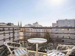 巴黎巴黎肖蒙山丘阿德吉奥公寓式酒店的美景阳台配有桌椅