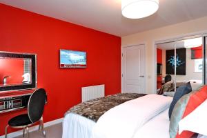 阿伯丁Trendy apartment a short drive from Aberdeen City的红色卧室设有1张床和1台电视