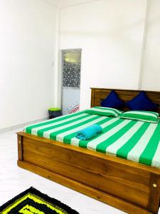 库鲁内格勒Royal Homes and Wellness Center的一间卧室配有一张带蓝色枕头的大型木制床。
