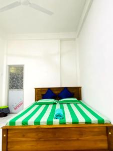 库鲁内格勒Royal Homes and Wellness Center的一间卧室配有绿色和白色的床以及蓝色枕头