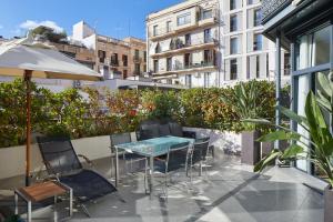 巴塞罗那巴塞罗那GL莫伽斯提克酒店&温泉的阳台的天井配有桌椅