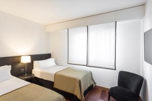 巴塞罗那巴塞罗那GL莫伽斯提克酒店&温泉的酒店客房,配有两张床和椅子