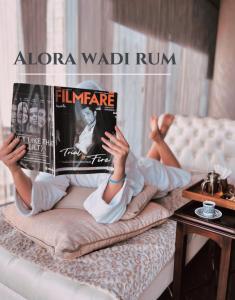 瓦迪拉姆Alora Wadi Rum Luxury的躺在床上读书的女人