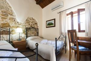基亚拉蒙泰-古尔菲Case Passamonte Agriturismo Resort & Rooms的一间卧室设有两张床和窗户。