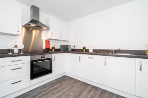 伯明翰Luxury Apartment - Twin Beds - Selly Oak - Off-street Parking - Free Netflix & Wifi - Top Rated 9CC的厨房配有白色橱柜和炉灶。