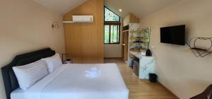 Tha KradanLake Hill Resort Kanchanaburi的卧室配有白色的床和电视。
