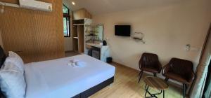 Tha KradanLake Hill Resort Kanchanaburi的卧室配有白色的床和2把椅子