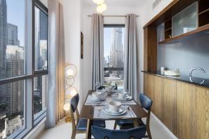 迪拜Class Home-Superb 1BR apartment with full Burj Khalifa View-5min walk to Dubai Mall的一间带桌椅和大窗户的用餐室