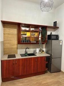 克拉科夫Wielopole Classy Rooms的厨房配有木制橱柜和不锈钢冰箱。