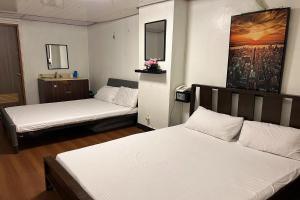 马尼拉Remedios Hotel的一间设有两张床的客房,