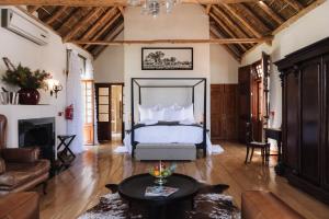 帕尔Adara Palmiet Valley Luxurious Boutique Farm Hotel的一间卧室设有一张床和一间客厅。