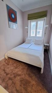 华沙克拉克夫郊区街“昼夜”公寓的卧室配有一张白色大床和两个窗户