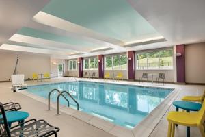 伊斯顿Home2 Suites By Hilton Easton的一个带桌椅的大型室内游泳池