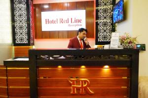 伊斯兰堡Hotel Red Line的一位在红线接待处打电话的人