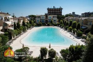 利多迪耶索罗Residence Borgo dei Fiori D03的一座带海滩和建筑的大型游泳池